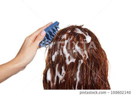 Side view of female wet hair with shampoo, massaging head with hair brush against white studio background. 108602140
