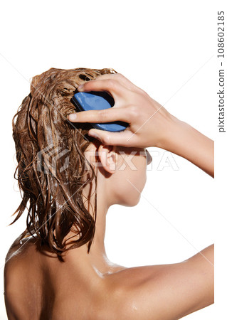 Side view of girl with wet hair with shampoo, massaging head with hair brush against white studio background. 108602185