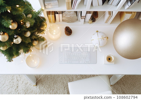 a christmas tree with gold ornaments on it and a computer keyboard in the fore - image is taken from above 108602794