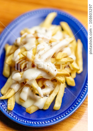 French fries with cheese sauce 108603297
