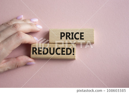 Price reduced symbol. Concept word Price reduced on wooden blocks. Businessman hand. Beautiful pink background. Business and Price reduced concept. Copy space 108603385