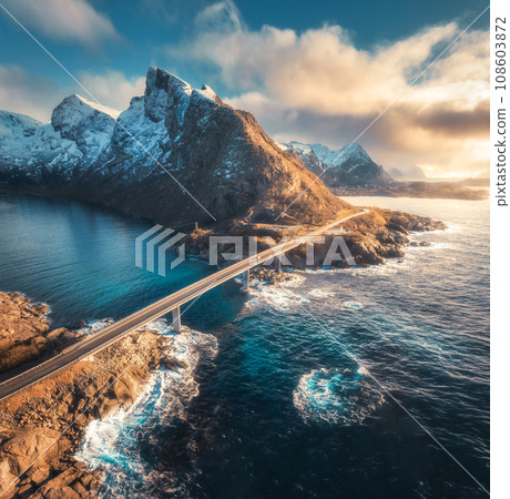 Aerial view of bridge, sea with waves and mountains at sunset 108603872