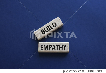Build empathy symbol. Wooden blocks with words Build empathy. Beautiful deep blue background. Psychology and Build empathy concept. Copy space. 108603898