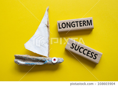 Longterm success symbol. Wooden blocks with words Longterm success. Beautiful yellow background with boat. Business and Longterm success concept. Copy space. 108603904