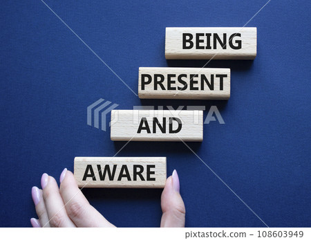 Being Present and Aware symbol. Wooden blocks with words Being Present and Aware. Doctor hand. Beautiful deep blue background. Psychology and Being Present and Aware concept. Copy space. Being Present and Aware symbol. Wooden blocks with words Being Present and Aware. Doctor hand. Beautiful deep blue background. Psychology and Being Present and Aware concept. Copy space. 108603949