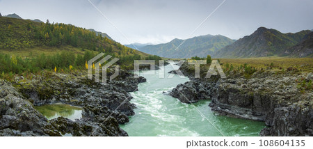 Panoramic scenic view of Katun river flowing amidst rocky coastlines against sky at Altai, Russia Panoramic scenic view of Katun river flowing amidst rocky coastlines against sky at Altai, Russia 108604135