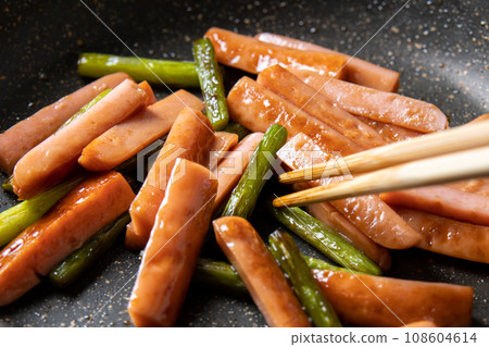 Stir-fried fish sausage and garlic sprouts, cooking scene. Stir-fried fish sausage and garlic sprouts, cooking scene. 108604614