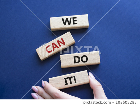 We can do it symbol. Concept words We can do it on wooden blocks. Beautiful deep blue background. Businessman hand. Business and We can do it concept. Copy space. 108605285