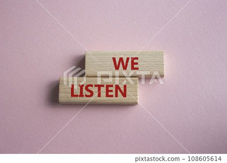 We listen symbol. Wooden blocks with words We listen. Beautiful pink background. Business and We listen concept. Copy space. 108605614
