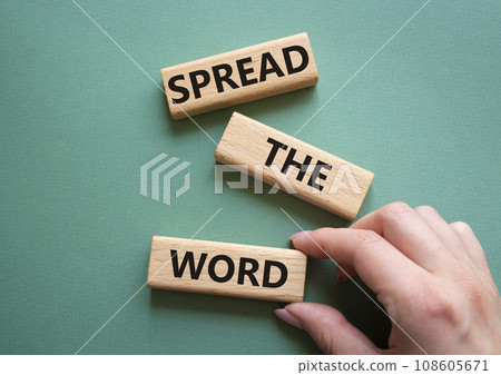 Spread the Word symbol. Concept wordsSpread the Word on wooden blocks. Beautiful grey green background. Businessman hand. Business and Spread the Word concept. Copy space. 108605671