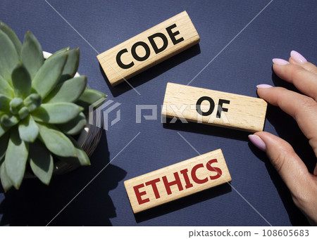 Code of ethics symbol. Concept words Code of ethics on wooden blocks. Beautiful deep blue background with succulent plant. Businessman hand. Business and Code of ethics concept. Copy space. 108605683