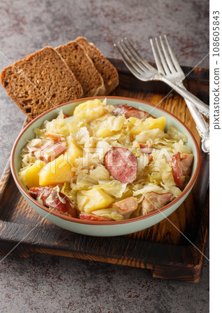 German Jager Kohl, hunter's cabbage with Sausage, Bacon and Potatoes close-up in a bowl. Vertical German Jager Kohl, hunter's cabbage with Sausage, Bacon and Potatoes close-up in a bowl. Vertical 108605843