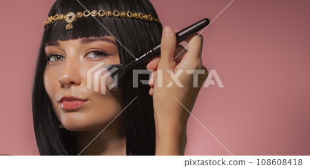 Applying Makeup by Brush. Cleopatra Style Beauty Fashion Portrait Shot 108608418