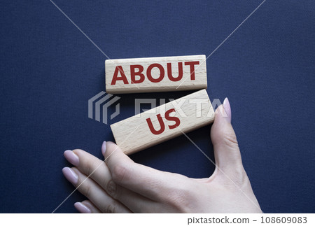 About us symbol. Wooden blocks with words About us. Beautiful deep blue background. Businessman hand. Business and About us concept. Copy space. About us symbol. Wooden blocks with words About us. Beautiful deep blue background. Businessman hand. Business and About us concept. Copy space. 108609083