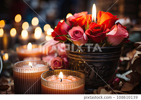 candles and flowers on a table with some roses in the vases next to each other lit candles are also visible 108610139