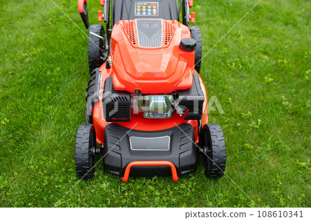 petrol self-propelled lawn mower on green grass petrol self-propelled lawn mower on green grass 108610341