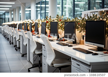 an office space with computers and christmas lights on the windows in the photo is taken from behind, while it's blurry 108610507