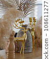 Golden deer decorative element with a gray stripped vase vertical. 108611277