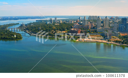 Aerial view over beautiful center Dnepr city with a wide river, green trees, buildings - in summer.. Beautiful downtown, aerial photography. 108611378