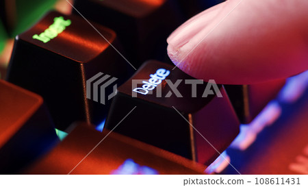 Man finger hovers over the Delete key for a few seconds before deciding to press it. Man finger hovers over the Delete key for a few seconds before deciding to press it. 108611431