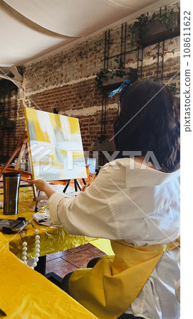 Woman with brush painting on canvas Woman with brush painting on canvas 108611622