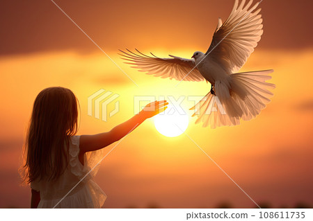 a little girl holding a white bird in her hand as the sun sets behind her and she is looking at it a little girl holding a white bird in her hand as the sun sets behind her and she is looking at it 108611735