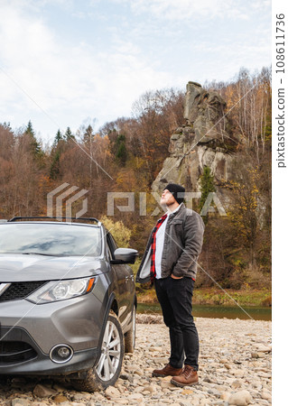 man near car at mountain river beach 108611736