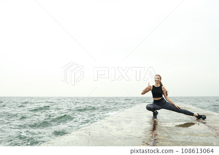 Woman in leggings at sea, space for text 108613064