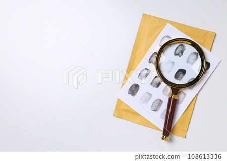 Magnifying glass with fingerprints on a white background Magnifying glass with fingerprints on a white background 108613336