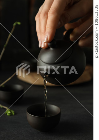 The concept of Asian tea, on a dark background with plants. The concept of Asian tea, on a dark background with plants. 108613338