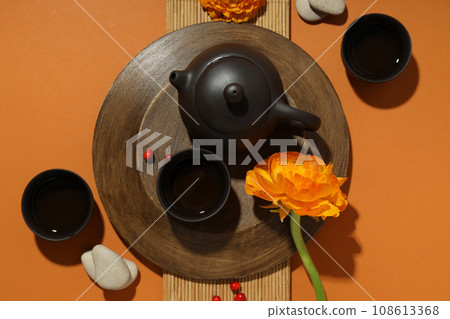 Asian tea concept, traditional dishes on orange background. Asian tea concept, traditional dishes on orange background. 108613368