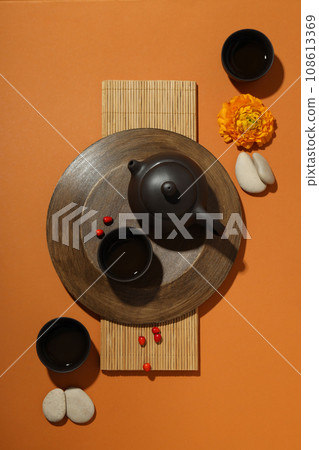 Asian tea concept, traditional dishes on orange background. Asian tea concept, traditional dishes on orange background. 108613369