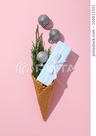 Waffle cone with a gift and a sprig of needles Waffle cone with a gift and a sprig of needles 108613501
