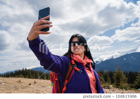 Woman makes self portrait during a mountain hike Woman makes self portrait during a mountain hike 108615906