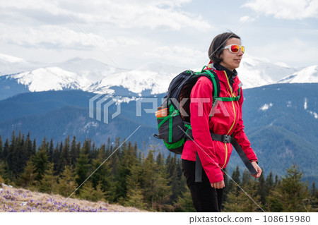 Woman with backpack enjoying the mountain view 108615980