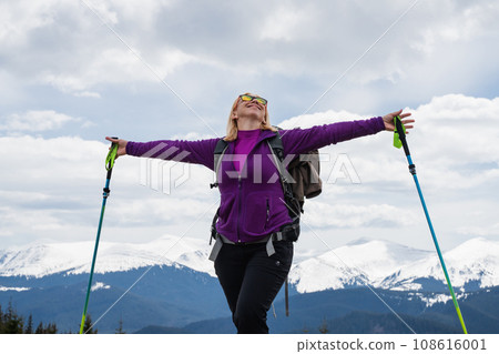 Woman with backpack enjoying the mountain view 108616001
