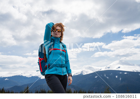 Woman with backpack enjoying the mountain view 108616011
