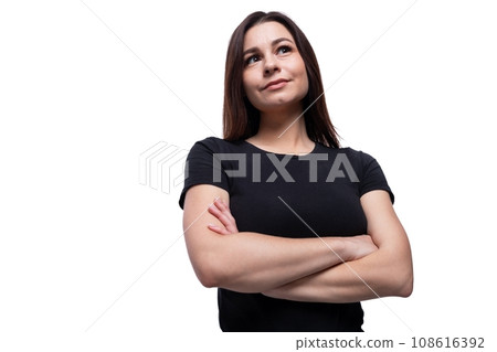Well-groomed 25 year old woman wearing a black basic T-shirt with her arms crossed in front of her Well-groomed 25 year old woman wearing a black basic T-shirt with her arms crossed in front of her 108616392