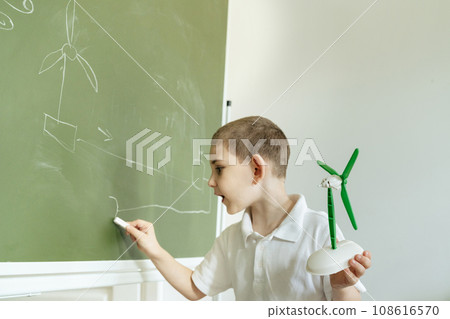 Kid shows and explains about wind generator model at school Kid shows and explains about wind generator model at school 108616570
