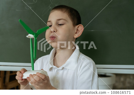 Kid shows and explains about wind generator model at school Kid shows and explains about wind generator model at school 108616571