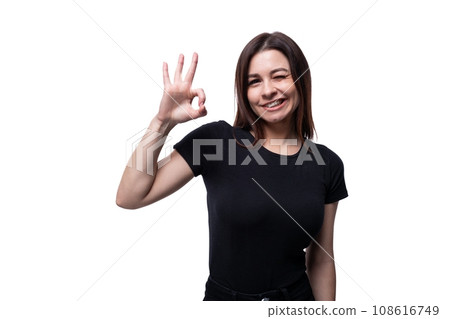 Young confident woman with black hair wearing a black T-shirt on a white background with copy space Young confident woman with black hair wearing a black T-shirt on a white background with copy space 108616749