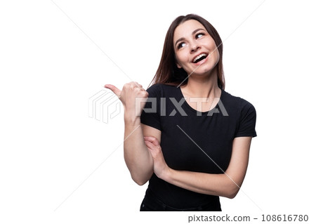 Young surprised woman with brown eyes dressed in a black T-shirt on a background with copy space 108616780