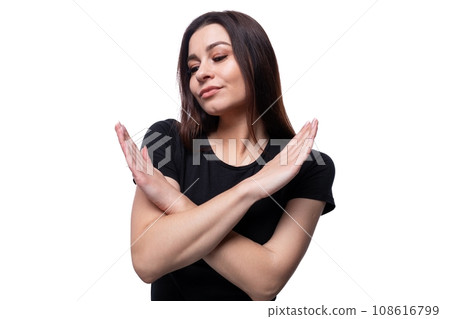Well-groomed 25 year old woman wearing a black basic T-shirt with her arms crossed in front of her 108616799