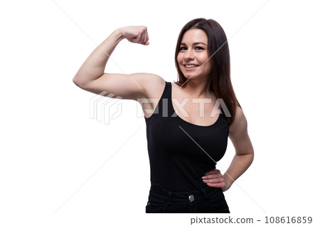 Happy young stylish woman with black hair showing strong muscles 108616859