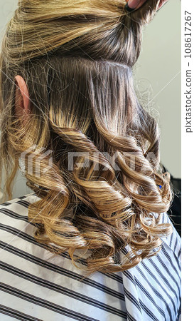 Hairstyle, curls and strands in a beauty salon. Long hair, beauty and health. 108617267