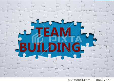 Team Building symbol. Concept word Team Building on white puzzle. Beautiful blue background. Business and Team Building concept. Copy space 108617468