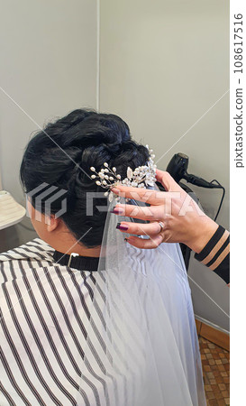 Wedding and holiday hairstyle. Braiding and hair styling in a beauty salon. Wedding and holiday hairstyle. Braiding and hair styling in a beauty salon. 108617516