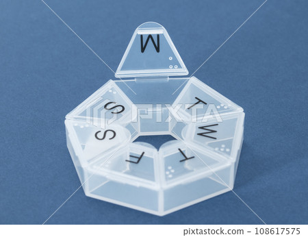 Pill organizer on blue. Medical concept, pharmacy bag with pill container or pill box. Pill organizer on blue. Medical concept, pharmacy bag with pill container or pill box. 108617575