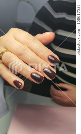Manicure and nail extensions with acrylic and gel. The design is made with dark gel polish. 108617585