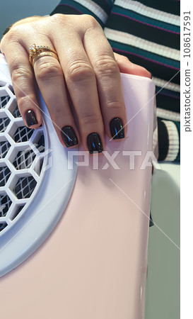 Manicure and nail extensions with acrylic and gel. The design is made with dark gel polish. 108617591